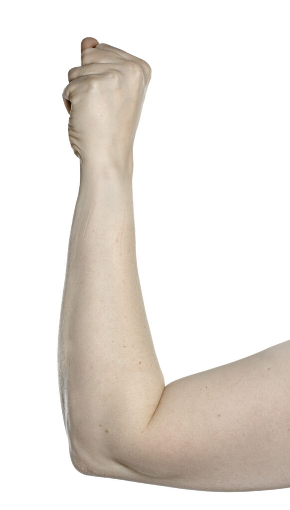 Picture shows elbow resting on a table with arm raised and hand closed to make a full fist