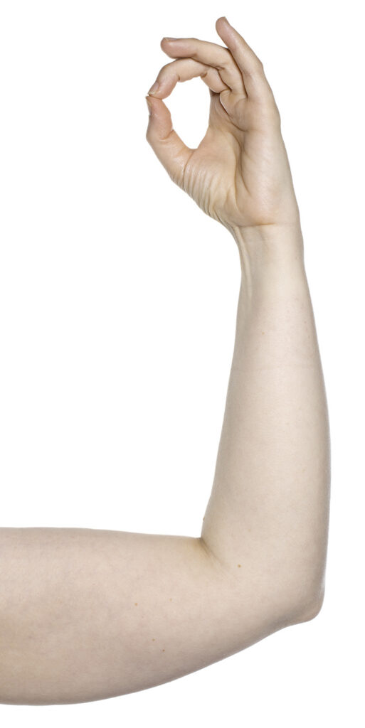 Photograph of elbow resting on a table the hand is raised and shows fingertip of third finger touching tip of thumb